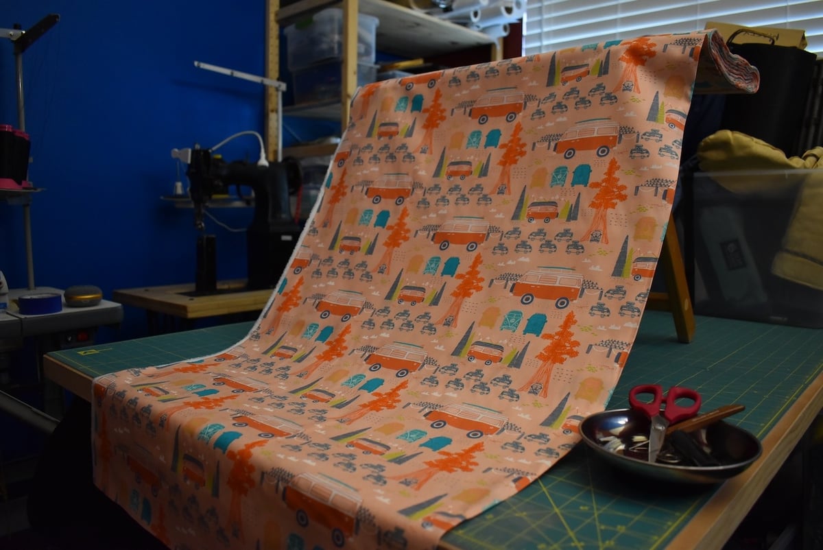 Salmon-colored fabric with VW bus motif draped over a stool.