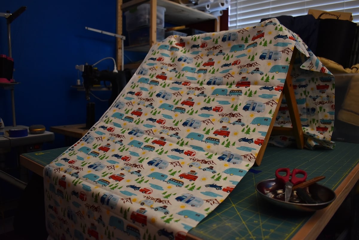 Light fabric with a cute travel trailer motif draped over a stool.