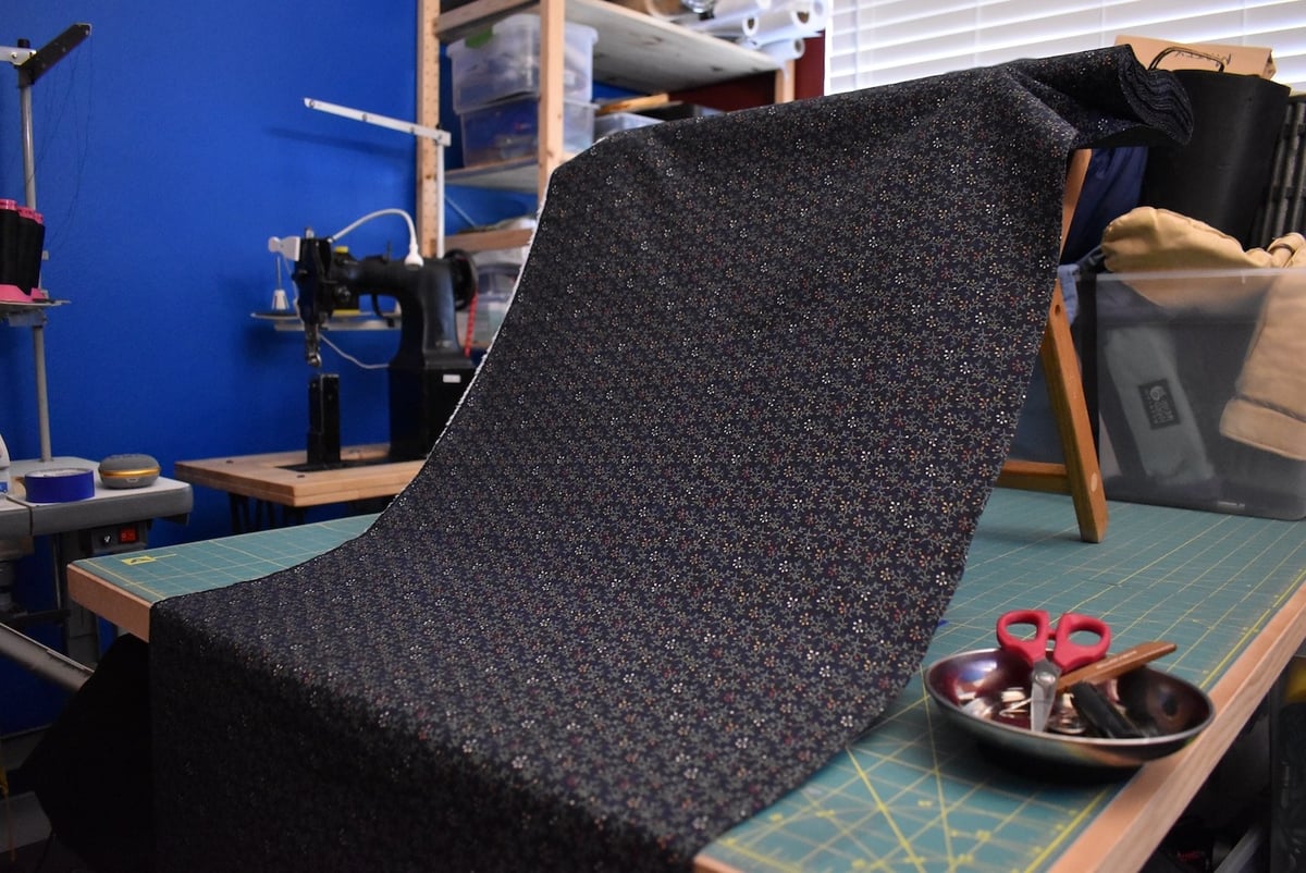 Navy fabric with a small floral motif draped over a stool.